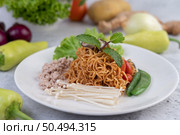 Stir-fried noodles with minced pork, edamame, tomatoes and mushrooms in a white plate. Стоковое фото, агентство Ingram Publishing / Фотобанк Лори