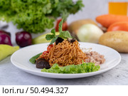 Stir-fried noodles with minced pork, edamame, tomatoes and mushrooms in a white plate. Стоковое фото, агентство Ingram Publishing / Фотобанк Лори