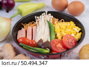 Stir fried noodle that combines corn, golden needle mushroom, tomato, sausage, edamame and spring onions in a frying pan. Стоковое фото, агентство Ingram Publishing / Фотобанк Лори