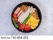 Stir fried noodle that combines corn, golden needle mushroom, tomato, sausage, edamame and spring onions in a frying pan. Стоковое фото, агентство Ingram Publishing / Фотобанк Лори