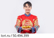 Man wear Cheongsam suit  give gold to his relative for lucky in chinese new year. Стоковое фото, агентство Ingram Publishing / Фотобанк Лори