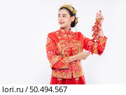 woman wear Cheongsam suit show the Firecrackers to client for selling in chinese new year. Стоковое фото, агентство Ingram Publishing / Фотобанк Лори