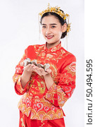 Woman wear Cheongsam suit and black shoe ready to give the gift money to relative. Стоковое фото, агентство Ingram Publishing / Фотобанк Лори
