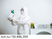 Disinfection specialist staff in personal protective equipment (ppe) suit, gloves, mask and face shield, cleaning Quarantine area with a bottle of pressurized spray disinfectant to remove covid-19. Стоковое фото, агентство Ingram Publishing / Фотобанк Лори