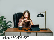 Happily Young asian woman with new normal, she Stay at home and works from home on digital tablet and use smartphone during self-isolation and quarantine covid-19 coronavirus outbreak. Стоковое фото, агентство Ingram Publishing / Фотобанк Лори