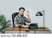 Happily Young handsome man with new normal, Stay at home and works from home on digital tablet and use smartphone during self-isolation and quarantine covid-19 coronavirus outbreak. Стоковое фото, агентство Ingram Publishing / Фотобанк Лори