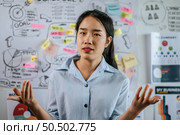 Young asian woman smiling and present planing of project on board in meeting room, copy space. Стоковое фото, агентство Ingram Publishing / Фотобанк Лори