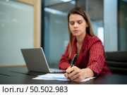 A businesswoman in a crimson gown Prepare to present work and new projects for consideration to the management team. in the huge conference room of the corporation. Стоковое фото, агентство Ingram Publishing / Фотобанк Лори