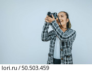 Portrait of Asian woman wearing casual clothes with a big smile on face looking to side,  taking pictures with camera. Isolated background in studio with blank space. Стоковое фото, агентство Ingram Publishing / Фотобанк Лори