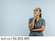 Portrait of Serious Asian woman glasses 30s in casual clothes looking aside and put hand prop up on chin isolated on wall background in studio. Mock up copy space. Стоковое фото, агентство Ingram Publishing / Фотобанк Лори