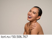 Head shot, portrait of cheerful woman hugging herself feelings with toothy smile posing isolated on gray background in studio, copy space. Стоковое фото, агентство Ingram Publishing / Фотобанк Лори