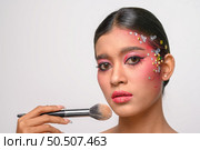 woman wearing pink makeup and holding a blush brush. Isolated on white background. Стоковое фото, агентство Ingram Publishing / Фотобанк Лори