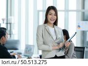 Portrait of an Asian female rookie in the new entrepreneurial team in the business of investment services. Стоковое фото, агентство Ingram Publishing / Фотобанк Лори