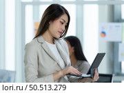 Portrait of an Asian female rookie in the new entrepreneurial team in the business of investment services. Стоковое фото, агентство Ingram Publishing / Фотобанк Лори