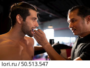 The boxer must wear a tooth collar before the fight to prevent the risk of injury from teeth clashing when punched in the chin or face, Muay Thai, Thai martial arts. Стоковое фото, агентство Ingram Publishing / Фотобанк Лори
