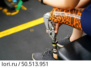 Young female with one prosthetic leg warms up by lifting light weights. Concept of living a woman’s life with a prosthetic limb. Стоковое фото, агентство Ingram Publishing / Фотобанк Лори