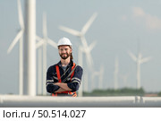 Engineer at Natural Energy Wind Turbine site with a mission to climb up to the wind turbine blades to inspect the operation of large wind turbines that converts wind energy into electrical energy. Стоковое фото, агентство Ingram Publishing / Фотобанк Лори