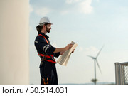 Engineer at Natural Energy Wind Turbine site with a mission to climb up to the wind turbine blades to inspect the operation of large wind turbines that converts wind energy into electrical energy. Стоковое фото, агентство Ingram Publishing / Фотобанк Лори