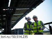 A team of electrical engineers is inspecting and maintaining solar panels at a solar panel site in the middle of a hundred acre field. Стоковое фото, агентство Ingram Publishing / Фотобанк Лори