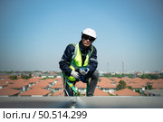 Engineer in charge of solar panel installation The installation of solar energy conversion into electricity for a warehouse is currently being investigated. Стоковое фото, агентство Ingram Publishing / Фотобанк Лори