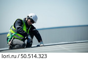 Engineer in charge of solar panel installation The installation of solar energy conversion into electricity for a warehouse is currently being investigated. Стоковое фото, агентство Ingram Publishing / Фотобанк Лори