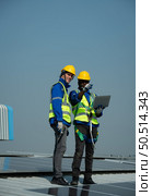 Both of Engineer in charge of solar panel installation The installation of solar energy conversion into electricity for a warehouse is currently being investigated. Стоковое фото, агентство Ingram Publishing / Фотобанк Лори