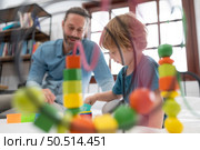 Father with little boy have fun playing with your new toys in the bedroom together. Toys that enhance children’s thinking skills. Стоковое фото, агентство Ingram Publishing / Фотобанк Лори