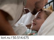 Before retiring to night, a father expresses his affection by kissing his daughter on the forehead. to get a good night’s rest. Стоковое фото, агентство Ingram Publishing / Фотобанк Лори