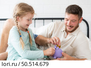Father teaches daughter how to save money so that the child will have the skills to manage money and live. Стоковое фото, агентство Ingram Publishing / Фотобанк Лори
