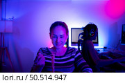 Asian women who rely heavily on computers to watch drama series until having to eat instant noodles in front of it, The game room has computers and LED neon lights that are spectacular. Стоковое фото, агентство Ingram Publishing / Фотобанк Лори
