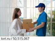 The delivery man brings the goods that the customer purchased and delivers them to the customer’s home. Стоковое фото, агентство Ingram Publishing / Фотобанк Лори