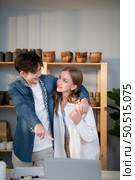 A young couple runs a small business making clay jewelry. They support one another as they work toward becoming larger business in the future. Стоковое фото, агентство Ingram Publishing / Фотобанк Лори