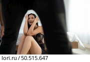 The enraged man tightened his hand to hit the frightened woman in the background. The concept of family and physical abuse. Стоковое фото, агентство Ingram Publishing / Фотобанк Лори