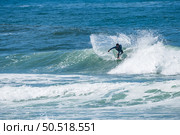 Young athletic surfer rides the wave in Furadouro Beach in Ovar, Portugal. Стоковое фото, агентство Ingram Publishing / Фотобанк Лори