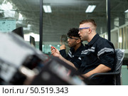 The robotic hand technology teacher is instructing new students on how to use electronic circuit boards and robotic hand commands for a variety of industrial applications. Стоковое фото, агентство Ingram Publishing / Фотобанк Лори