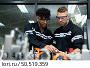The robotic hand technology teacher is instructing new students on how to use electronic circuit boards and robotic hand commands for a variety of industrial applications. Стоковое фото, агентство Ingram Publishing / Фотобанк Лори