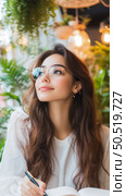 Envisioning Ideas: A Young Woman in Thoughtful Pose at a Cafe. Стоковое AI-изображение, AI-художник Данила Большаков / Фотобанк Лори