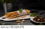Fresh baked homemade grissini bread sticks in white ceramic tray with olive oil and basil herbs over kitchen counter top. Стоковое фото, агентство Ingram Publishing / Фотобанк Лори