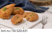 Meat patties and parsley leaves on white ceramic dishes in a kitchen counter top. Стоковое фото, агентство Ingram Publishing / Фотобанк Лори
