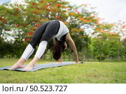 Young female with outdoor activities in the city park, Yoga is her chosen activity. Стоковое фото, агентство Ingram Publishing / Фотобанк Лори