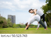 Young female and little girl with outdoor activities in the city park, Yoga is her chosen activity. Стоковое фото, агентство Ingram Publishing / Фотобанк Лори