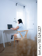 Asian woman with prosthetic leg working to laptop in the living room. Стоковое фото, агентство Ingram Publishing / Фотобанк Лори
