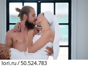 Young couple in love, A man carrying woman in towels to bathe together in bathroom. Стоковое фото, агентство Ingram Publishing / Фотобанк Лори
