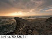 View south of Furadouro beach in Ovar on a stormy day at sunset. Стоковое фото, агентство Ingram Publishing / Фотобанк Лори