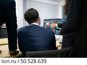 Diverse team of businessmen and engineers consultation on the engineering of a wind turbine that converts wind energy to electricity in the office. Стоковое фото, агентство Ingram Publishing / Фотобанк Лори