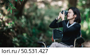 Young pretty woman use digital camera taking a photo beautiful nature while camping in forest with happiness, copy space. Стоковое фото, агентство Ingram Publishing / Фотобанк Лори