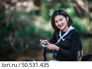 Young pretty woman use digital camera taking a photo beautiful nature while camping in forest with happiness, copy space. Стоковое фото, агентство Ingram Publishing / Фотобанк Лори