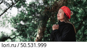 Portrait of Asian young woman in winter costume praying in the morning at the woodland. Christianity and faith hope love concept. Стоковое фото, агентство Ingram Publishing / Фотобанк Лори