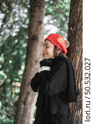 Portrait of Asian young woman in winter costume praying in the morning at the woodland. Christianity and faith hope love concept. Стоковое фото, агентство Ingram Publishing / Фотобанк Лори