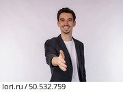Portrait of smiling handsome businessman extend hand for handshake, look friendly, greet you, hi gesture, standing over white background. Стоковое фото, агентство Ingram Publishing / Фотобанк Лори
